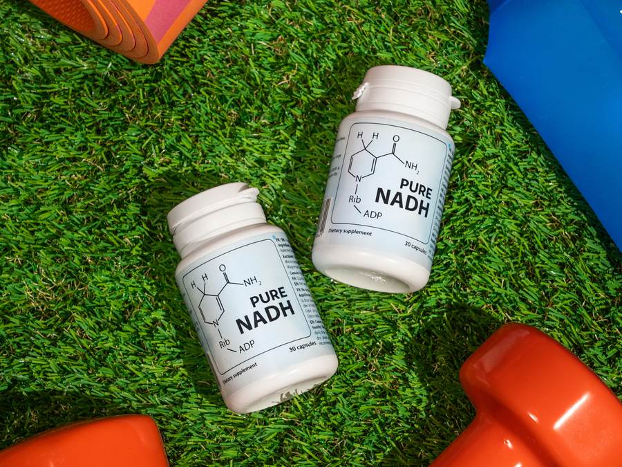 PureNADH bottles next to workout equipment on grass